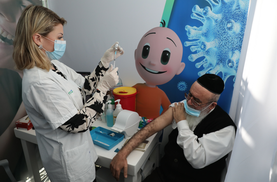  12月22日，在以色列特拉维夫的新冠疫苗接种中心，一名老人接种新冠疫苗。图/新华社发