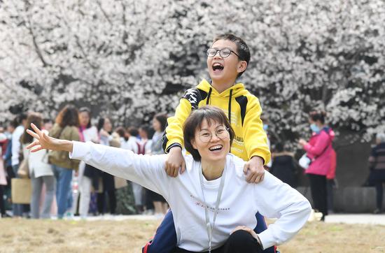 3月13日，广东援鄂医疗队成员梁仕凤带着孩子来到武汉大学赏樱游玩。