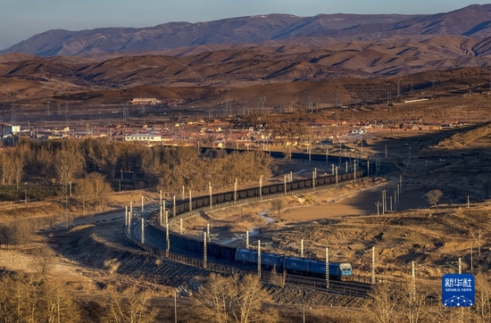  2021年12月23日，一列万吨煤炭列车行驶在内蒙古乌兰察布市卓资县境内。新华社发（纪恩泉 摄）