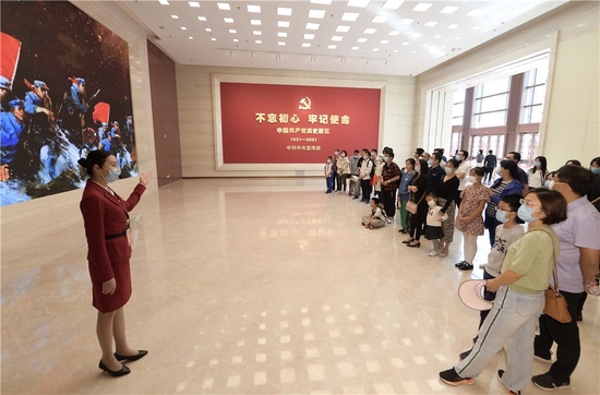 参观者在中国共产党历史展览馆展厅聆听工作人员讲解（2021年10月1日摄）。新华社记者 李贺 摄