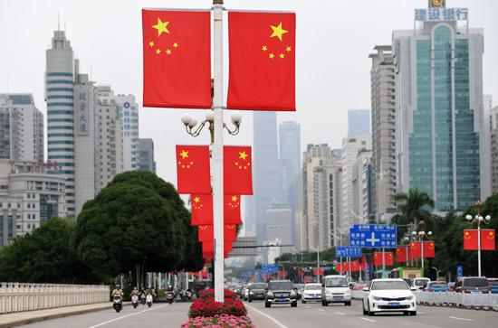 10月1日,车辆从挂满国旗的广西南宁市南湖大桥上经过。(新华社记者陆波岸摄)