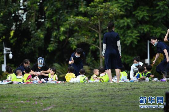 老师带着孩子在深圳福田区的荔枝公园玩耍（9月22日摄）。新华社记者 毛思倩 摄
