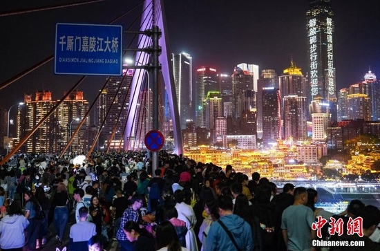 4月29日，“五一”假期首日，重庆千厮门嘉陵江大桥再度在晚间关闭车辆通行，保障游客安全赏景拍照。中新网图