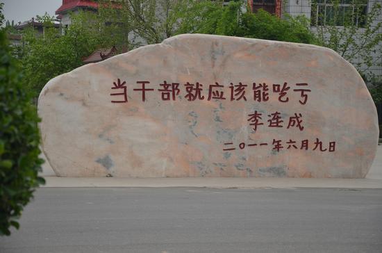 △西辛庄办公楼前的石碑。“当干部就应该能吃亏”是李连成写的。
