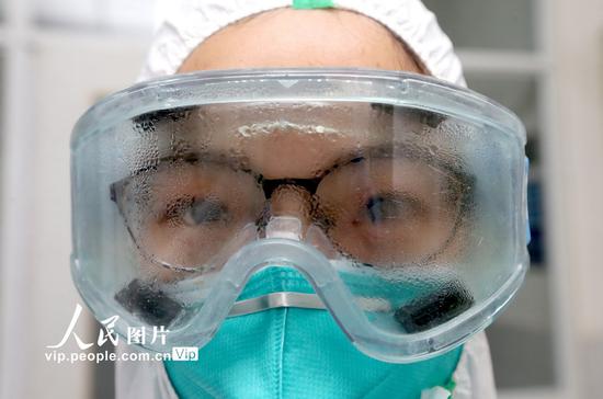 2020年2月3日，在隔离病区工作一上午的护士廖娜身穿全封闭的防护服，嘴里呼出的热气在护目镜上凝结成小水滴。张忠苹/人民图片