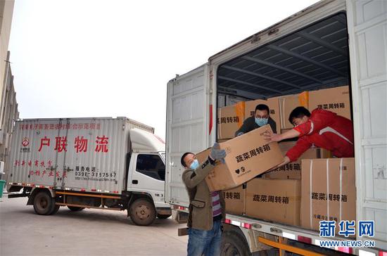 在河南省渑池县，物流公司的工作人员在搬运货物（3月26日摄）。新华社发