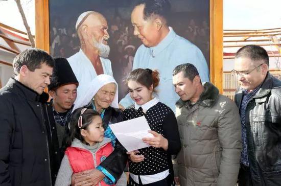 ▲  托乎提汗·库尔班一家人在读习近平总书记的回信。