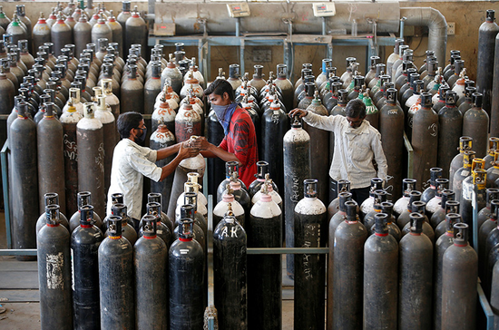  2021年4月25日，印度艾哈迈达巴德的一家工厂，工人准备为氧气瓶充气。图|澎湃影像