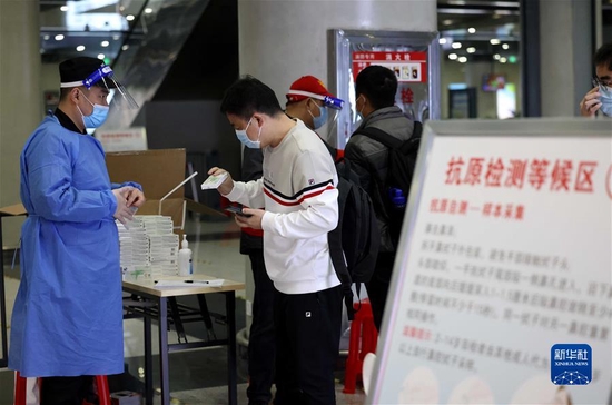  3月27日，在合肥火车站出站大厅，出站旅客领取免费发放的抗原检测试剂。新华社发（解琛 摄）