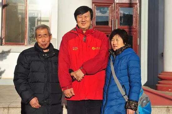  2015年1月6日，新华社记者汤计（中）与呼格吉勒图父母合影。