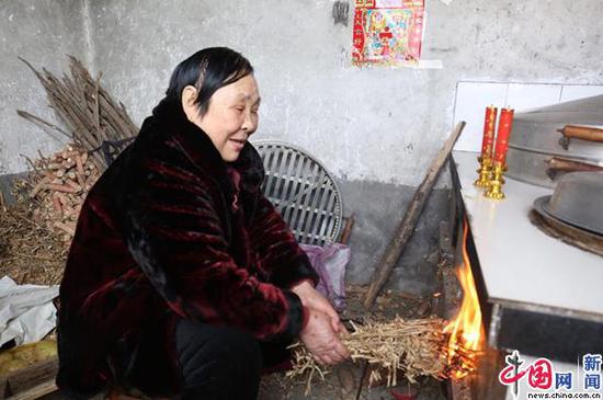 2月5日，邓桂荣正在烧地锅做饭。中国网 郭泽涵 摄