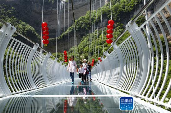 5月2日,游人在湖北省宜昌市秭归县三峡竹海生态景区玻璃天桥上游. .