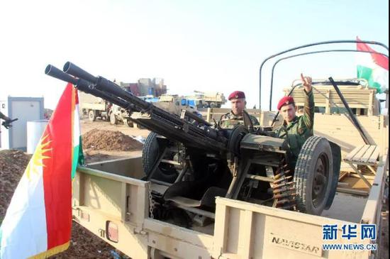位于伊拉克北部祖马尔镇的库尔德武装人员展示其重机枪等重型武器 （图源：新华网）