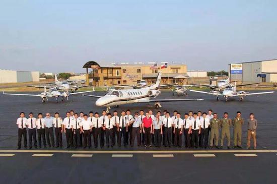 美国USAG航校丹顿校区教员和学员合影，后面是学员训练使用的PA-34-200机型