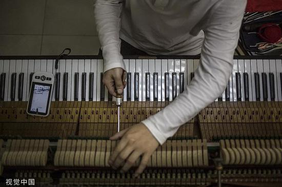 盲人调音师正在给钢琴调音。图片来自视觉中国