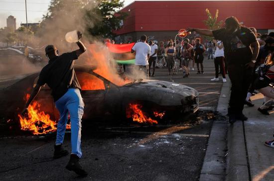 ↑抗议者在Target商店前点燃了一辆汽车。图据路透社
