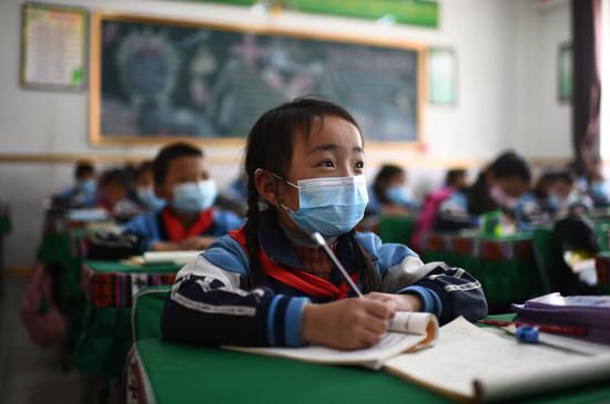↑ 玉树市第三完全小学二年级一班学生求永藏嘎在上课（2020年4月9日摄）。