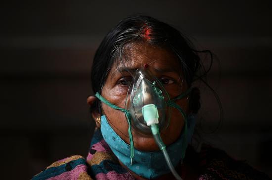  5月2日，一名女子在印度加济阿巴德吸氧。新华社 图