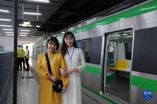 11月6日，在越南首都河内吉灵站，两名女子在轻轨列车前留影。中企承建的越南首条城市轻轨项目交接仪式当天在河内举行，标志着该项目投入运行。新华社记者 陶军 摄