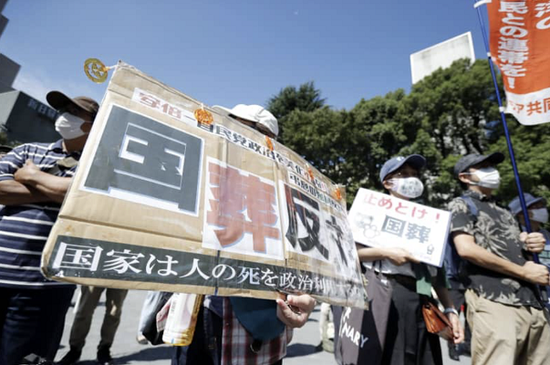  举着“反对国葬”标语的抗议民众，日媒当地时间27日11时6分东京都千代田区摄
