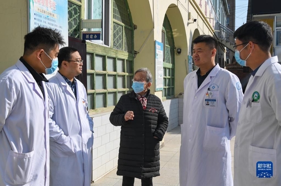  路生梅在陕西省榆林市佳县人民医院与年轻医生交流（11月16日摄）。新华社发（邹竞一 摄）