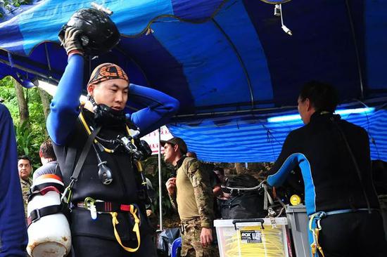 7月2日，在泰国清莱府，一名中国搜救队员（左）参与搜救任务后返回。新华社发