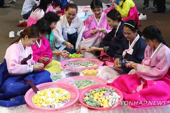 19日,中秋节临近,首尔外籍新娘穿韩服学习制作松饼.(韩联社)