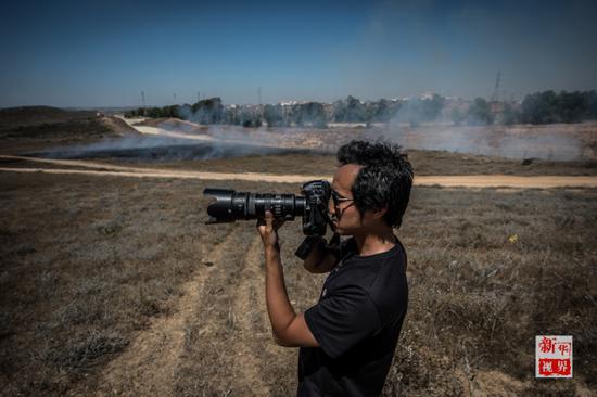  2014年7月29日，新华社耶路撒冷分社记者李睿在靠近加沙地带北部边境的以色列小镇代罗特附近34号公路旁。
