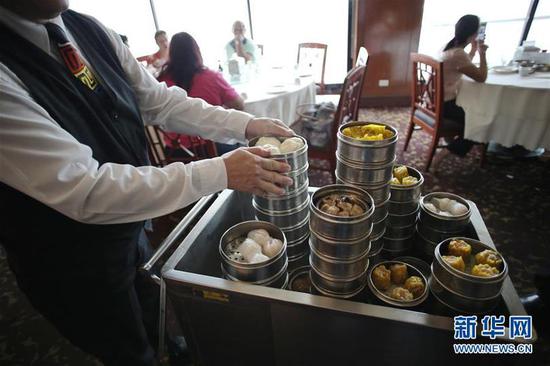 这是2015年5月13日，在巴拿马首都巴拿马城“金色独角兽”中餐馆内，服务员为顾客准备食物。新华社 毛里西奥·巴伦苏埃拉摄