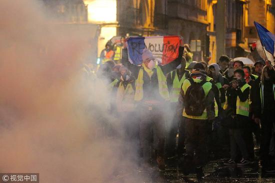 示威者挥舞的法国国旗上写着“革命”（图源：视觉中国）