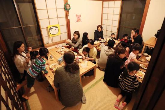  妈妈和孩子在朝霞儿童食堂吃晚餐。