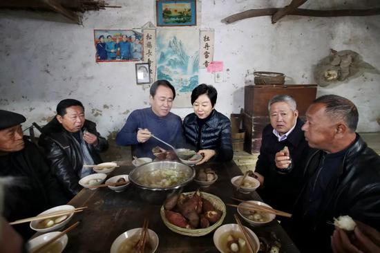 许家印夫妇和同乡们在堂屋吃忆苦思甜饭