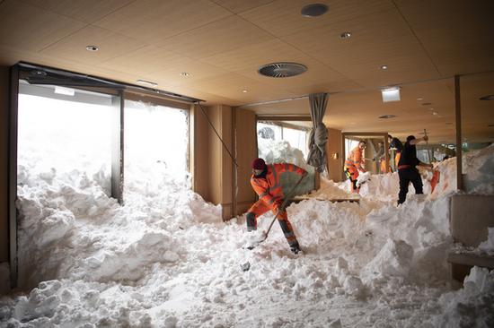 救援人员正在清理倒灌进酒店的大雪（图源：《南德意志报》）