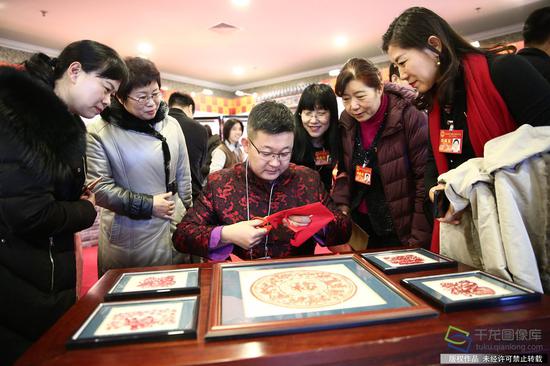 1月13日，北京市人大代表观看非遗传承人剪纸（图片来源：tuku.qianlong.com）。千龙网记者 万小军摄