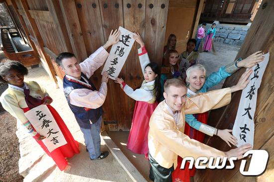汉字对联:韩国人提前庆祝立春:贴汉字对联 白纸黑字亮了 在韩外国留学生体验贴对联。(韩媒News1)