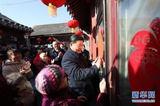 2月1日，中共中央总书记、国家主席、中央军委主席习近平在北京看望慰问基层干部群众，考察北京冬奥会、冬残奥会筹办工作。这是1日上午，习近平在前门东区草厂四条胡同32号院，高兴地拿起一幅“福”字，亲自贴到门上，给这里的老街坊们拜年。 新华社记者 鞠鹏 摄