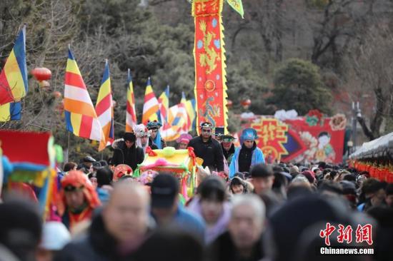 2月9日，游客在北京八大处公园庙会上游玩，观看传统民间花会表演。 中新社记者 盛佳鹏 摄  