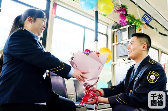  2019年2月14日，是范嘉宇和汪霞这对公交小夫妻在电车101路一同工作的800天。图为范嘉宇向汪霞送花。千龙网发