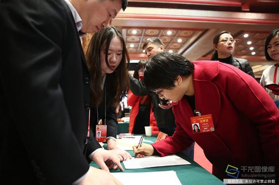 3月3日，十三届全国人大二次会议北京团代表抵达北京会议中心报到。图为人大代表田春艳签字登记报到（图片来源：tuku.qianlong.com）。千龙网记者 万小军摄