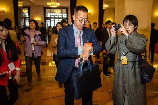 两会照片:2019两会现场照片精选 周强张军与人握手打招呼 3月3日,北京人民大会堂,全国政协十三届二次会议开幕会前,一名女记者对着全国政协委员、新东方教育科技集团董事长俞敏洪拍照。中国青年报·中青在线 中国青年网记者 李隽辉/摄