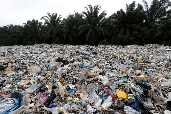  （马来西亚非法回收工厂外塑料垃圾铺满海滩，图片来源：路透社。）