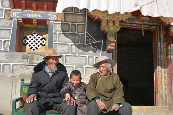 两位兄弟老人在自家院内与曾孙子一起晒太阳。记者 扎西顿珠 张斌 摄