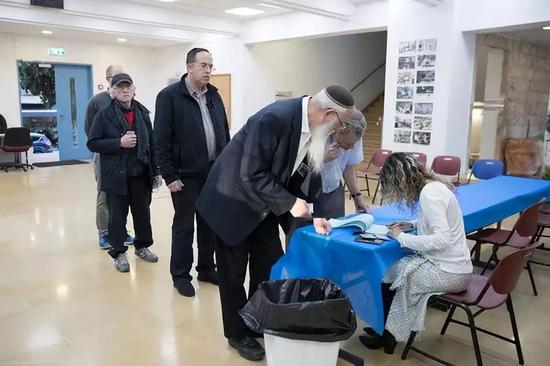  4月9日，在耶路撒冷的一处投票点，以色列选民确认身份信息。新华社记者 郭昱 摄