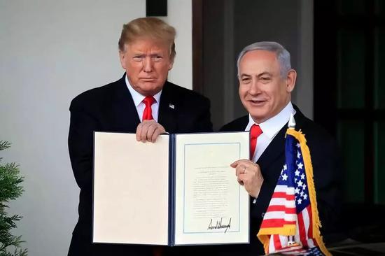 3月25日，在美国华盛顿白宫，美国总统特朗普（左）和到访的以色列总理内塔尼亚胡展示正式承认以色列对戈兰高地主权的公告。新华社/美联