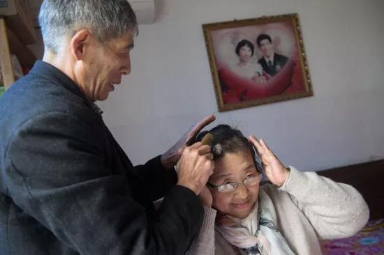 4月11日，老伴陈洪明为准备给视障人士解说电影《可可西里》的吴素环梳头。