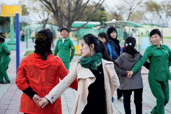 傍晚的平壤街头，朝鲜民众在学习跳舞。摄影/汪许凯