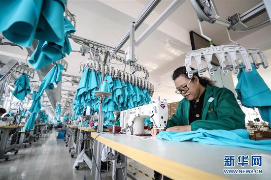 工人在辽宁葫芦岛益丰（集团）运动服饰有限公司生产车间加工泳衣（3月6日摄）。 新华社记者 潘昱龙 摄