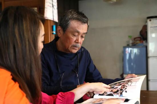 4月26日，在日本东京，秋山亮二（右）和女儿秋山都在家中回顾《你好小朋友》中的作品。新华社记者杜潇逸 摄