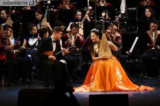 △中国琵琶演奏家赵聪和俄罗斯音乐家尼古拉伊丘克在表演曲目《绽放》。文艺演出持续了一小时，有约120名中俄艺术家参演。