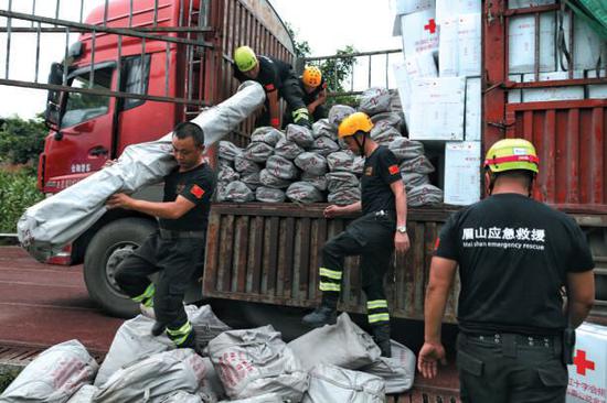  ▲昨日，救援人员从货车上搬下帐篷支架，准备向安置点增援。新京报记者 彭子洋 摄